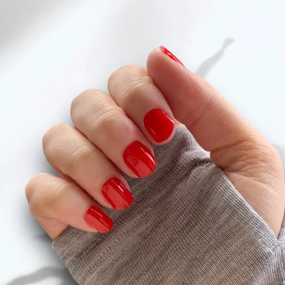 A woman's hand wearing Nice and Nailed RUBY RED GEL WRAP nail polish.